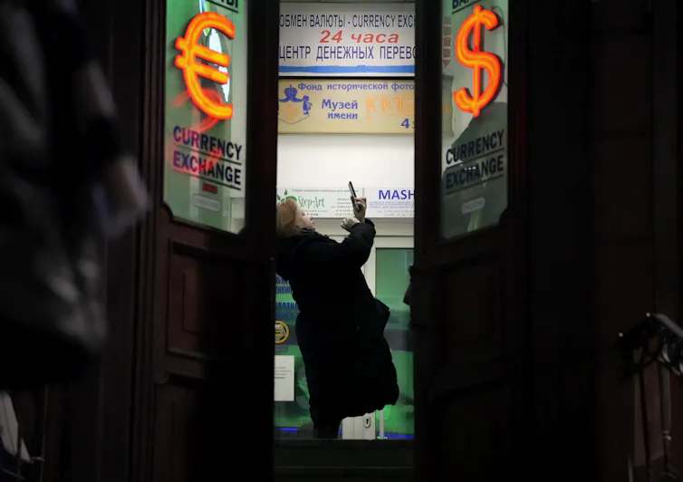 A woman stands in the doorway of a building