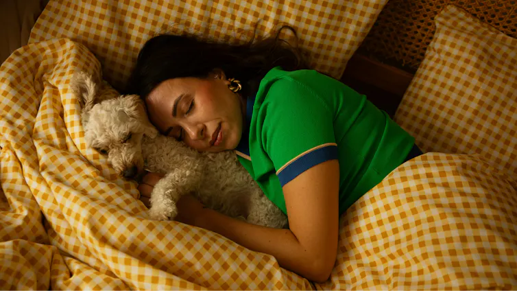 ¿Te gusta dormir con tu mascota? La ciencia revela que existe un compromiso complicado 1 Una mujer duerme en la cama con un perro.