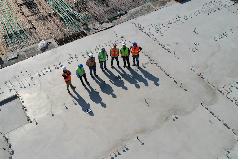 Group of people in safety gear stand on the unfinished roof of a data centre.