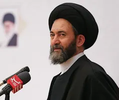 a Muslim cleric with a beard and a turban and a microphone