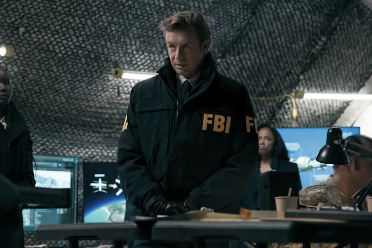 a blonde man in an FBI jacket