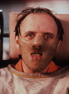 a man in a leather mask and straitjacket