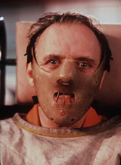 a man in a leather mask and straitjacket