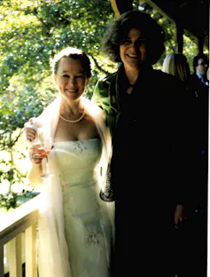 a small blonde woman in a wedding dress and a taller, dark-haired one