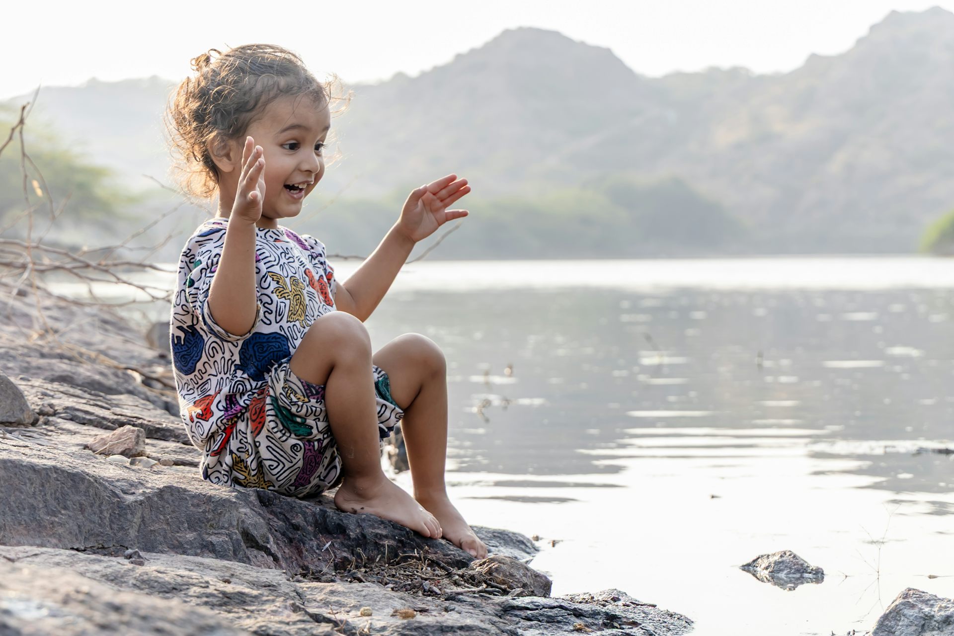 Child expressing awe and curiosity at a lake.