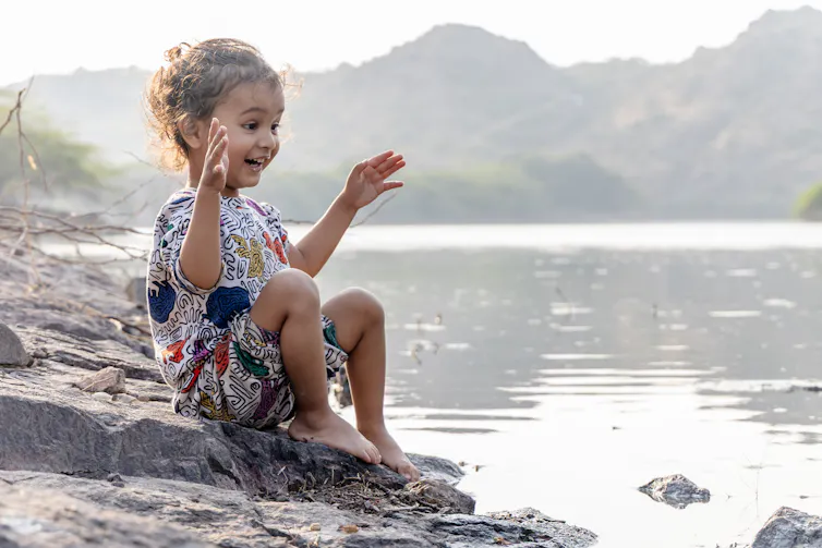 Child expressing awe and curiosity at a lake.
