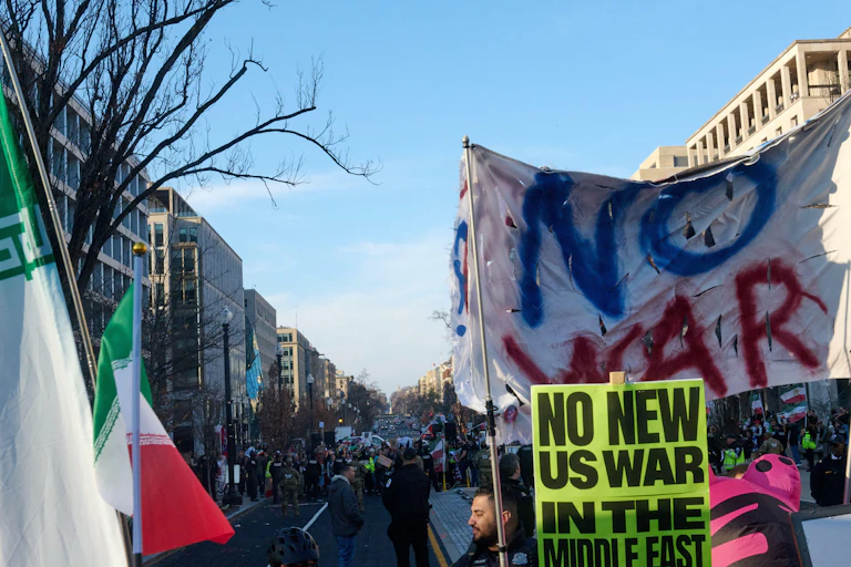 Anti-war activists holding banners saying No War protest in Washington against the US and Israeli bombing campaign in Iran, March 2026.
