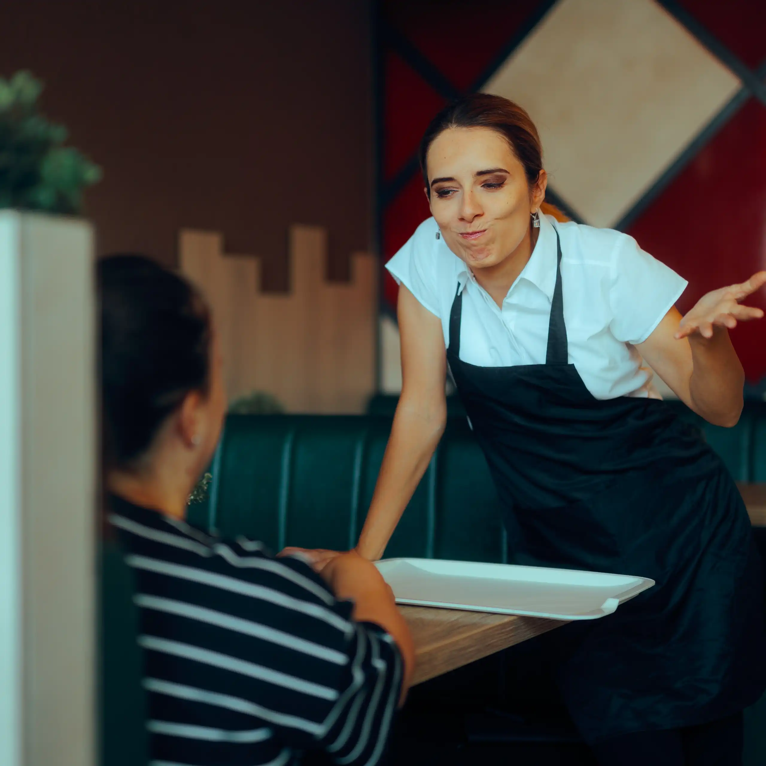 Una camarera discutiendo con un cliente en un restaurante