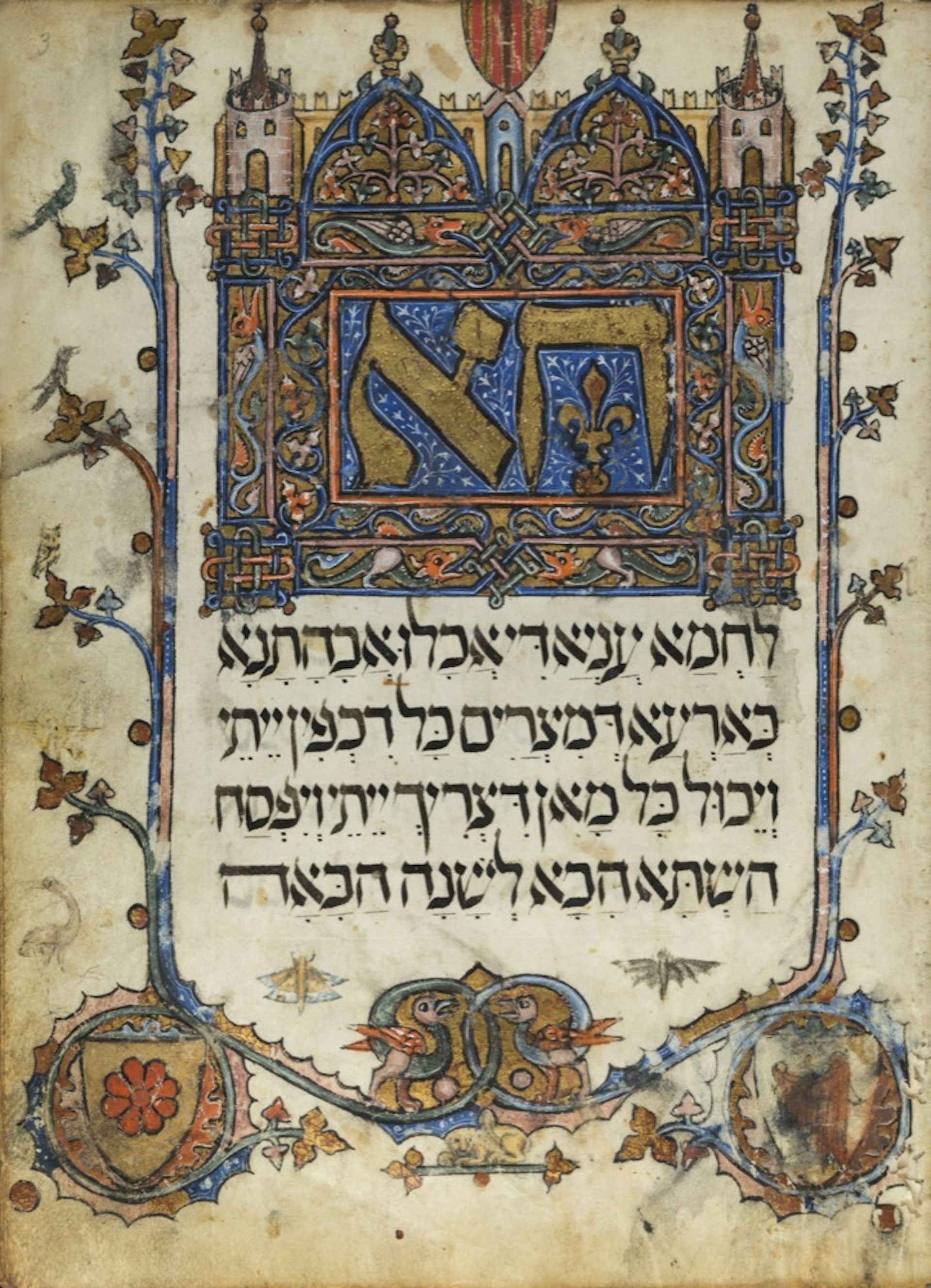 Una página de un manuscrito iluminado con un borde floral y letras hebreas de colores ornamentados.