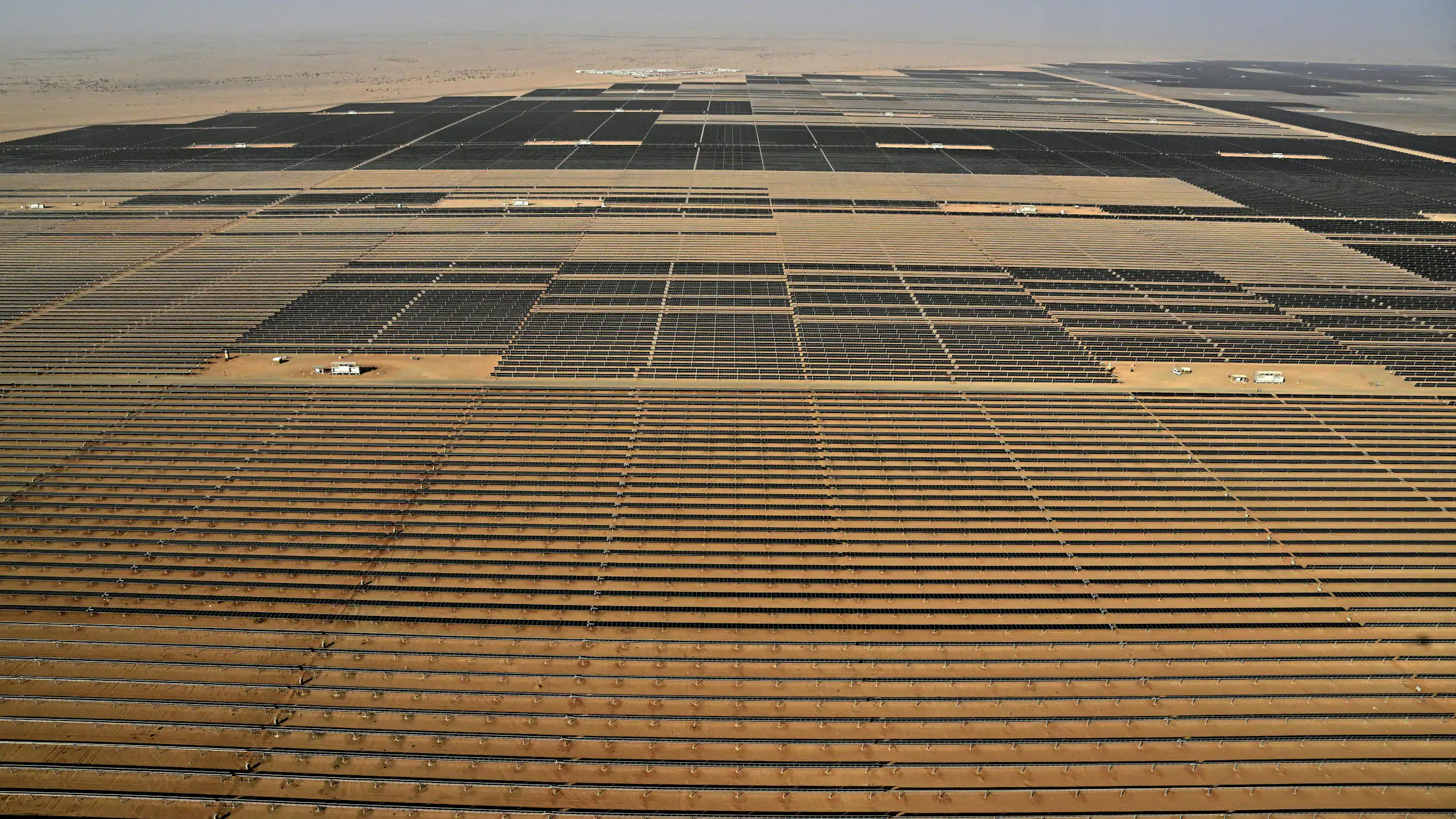 An aerial view of a very large array of solar panels in a desert.
