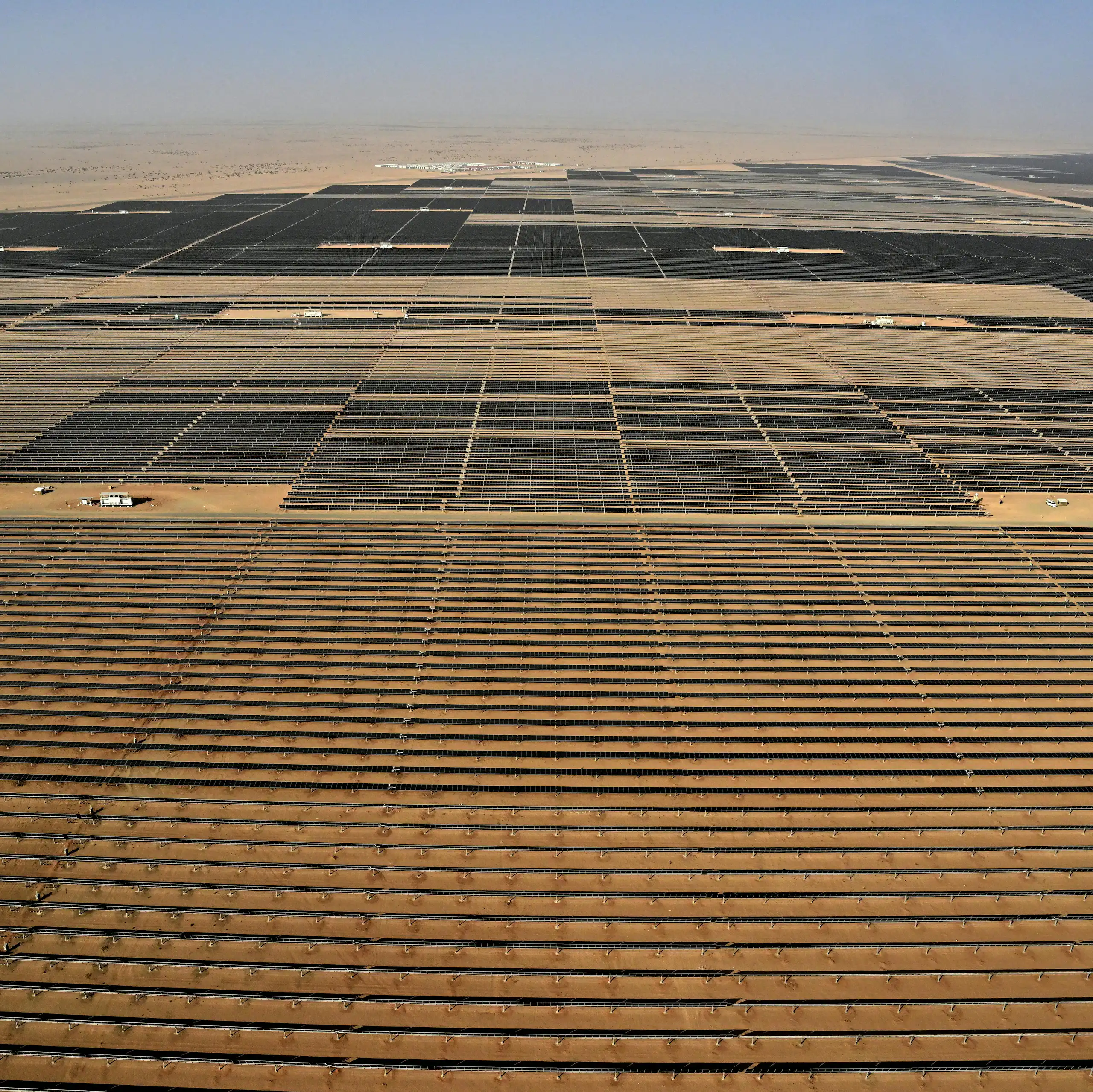 An aerial view of a very large array of solar panels in a desert.