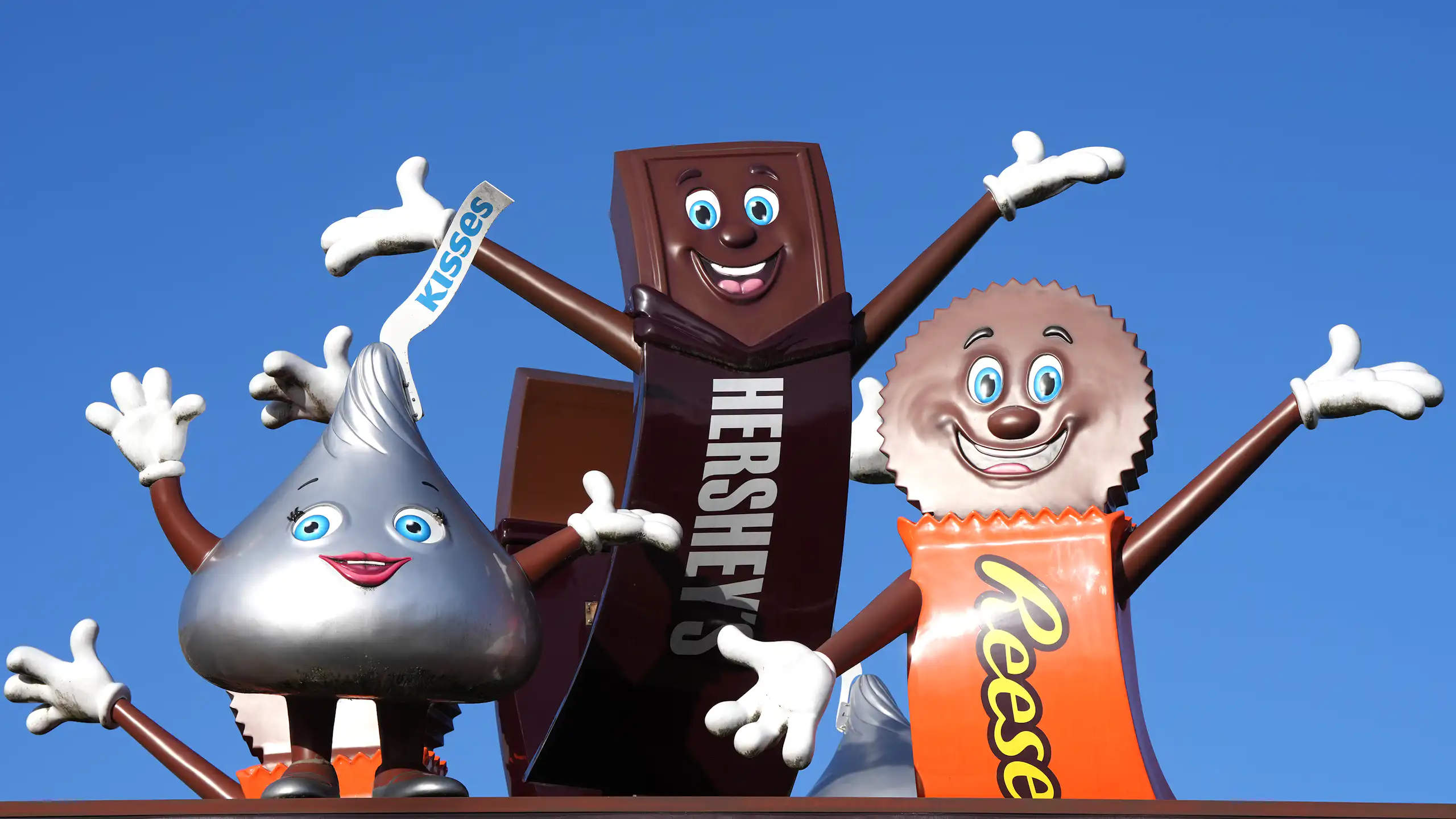 Statues of a smiling and waving Hershey's Kiss, Hershey's Chocolate Bar and Reese's Peanut Butter Cup