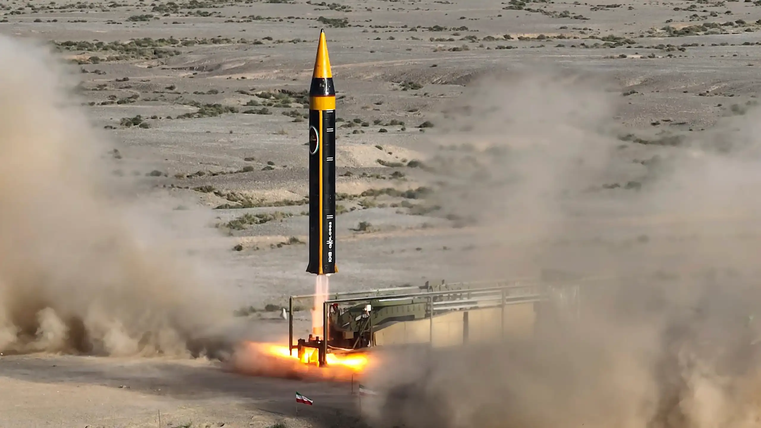 a large missile just beginning to lift off from a desert landscape
