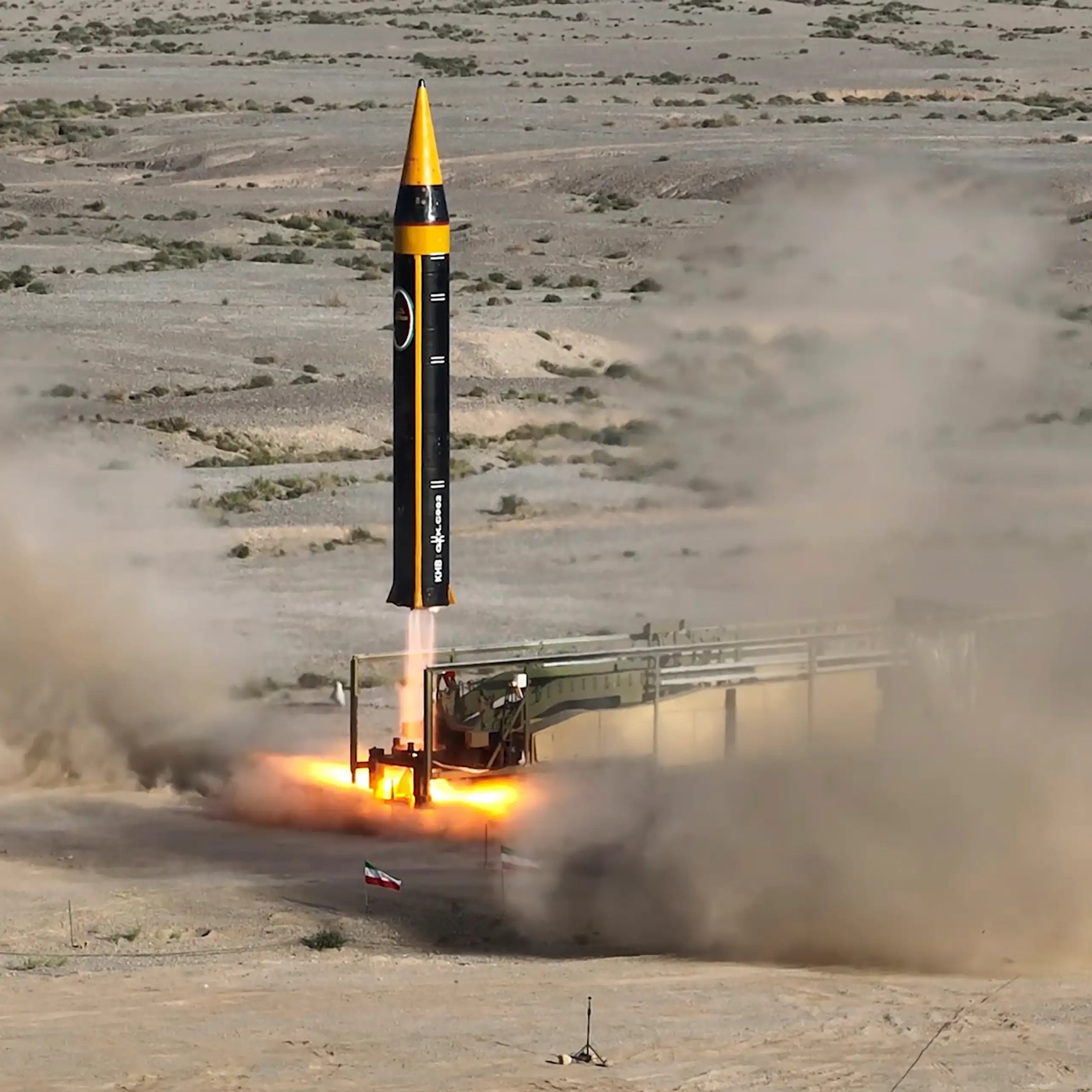 a large missile just beginning to lift off from a desert landscape