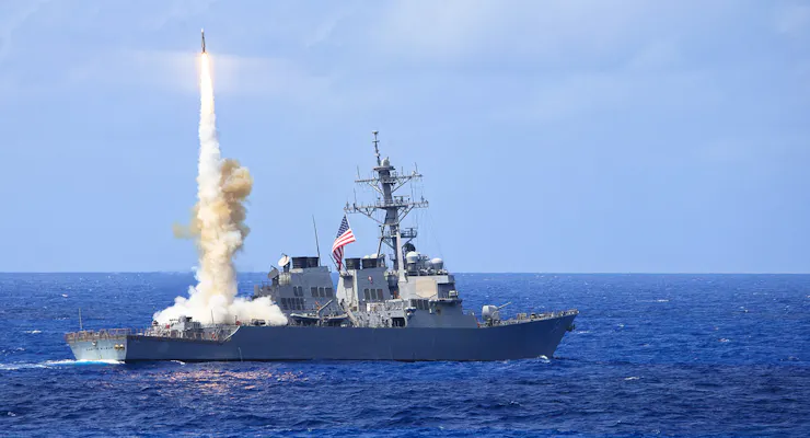 a missile rises from a navy warship at sea