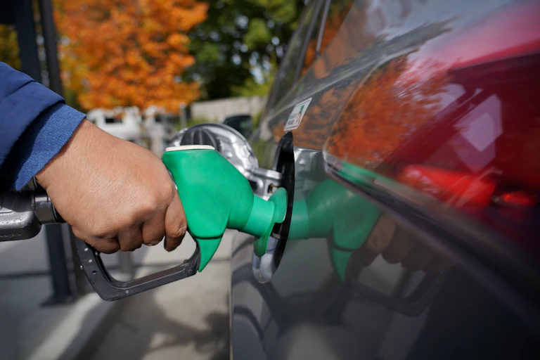 Detail of hand filling up a combustion engine car at the petrol station