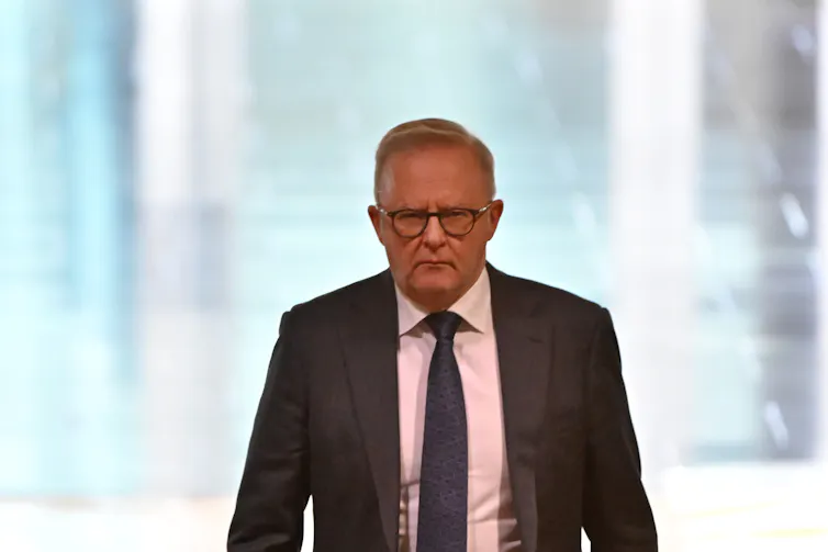 Anthony Albanese walks with a frown on his face