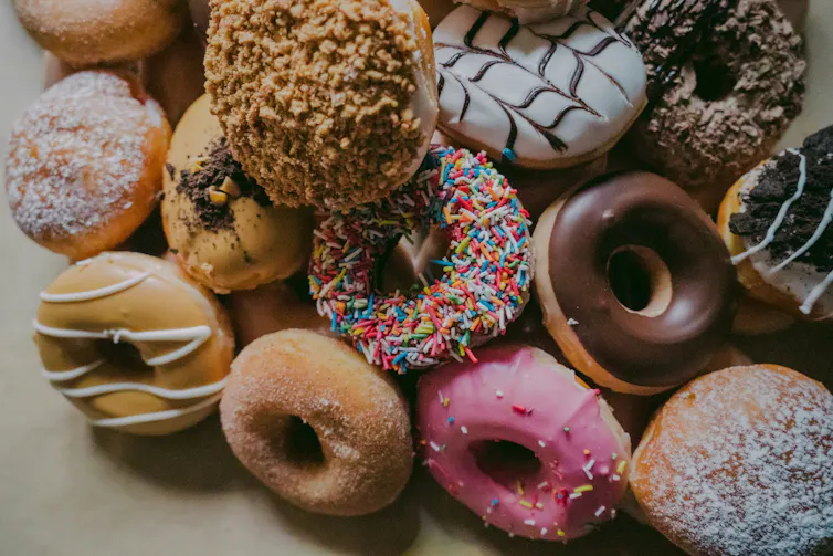 A pile of variously iced donuts.