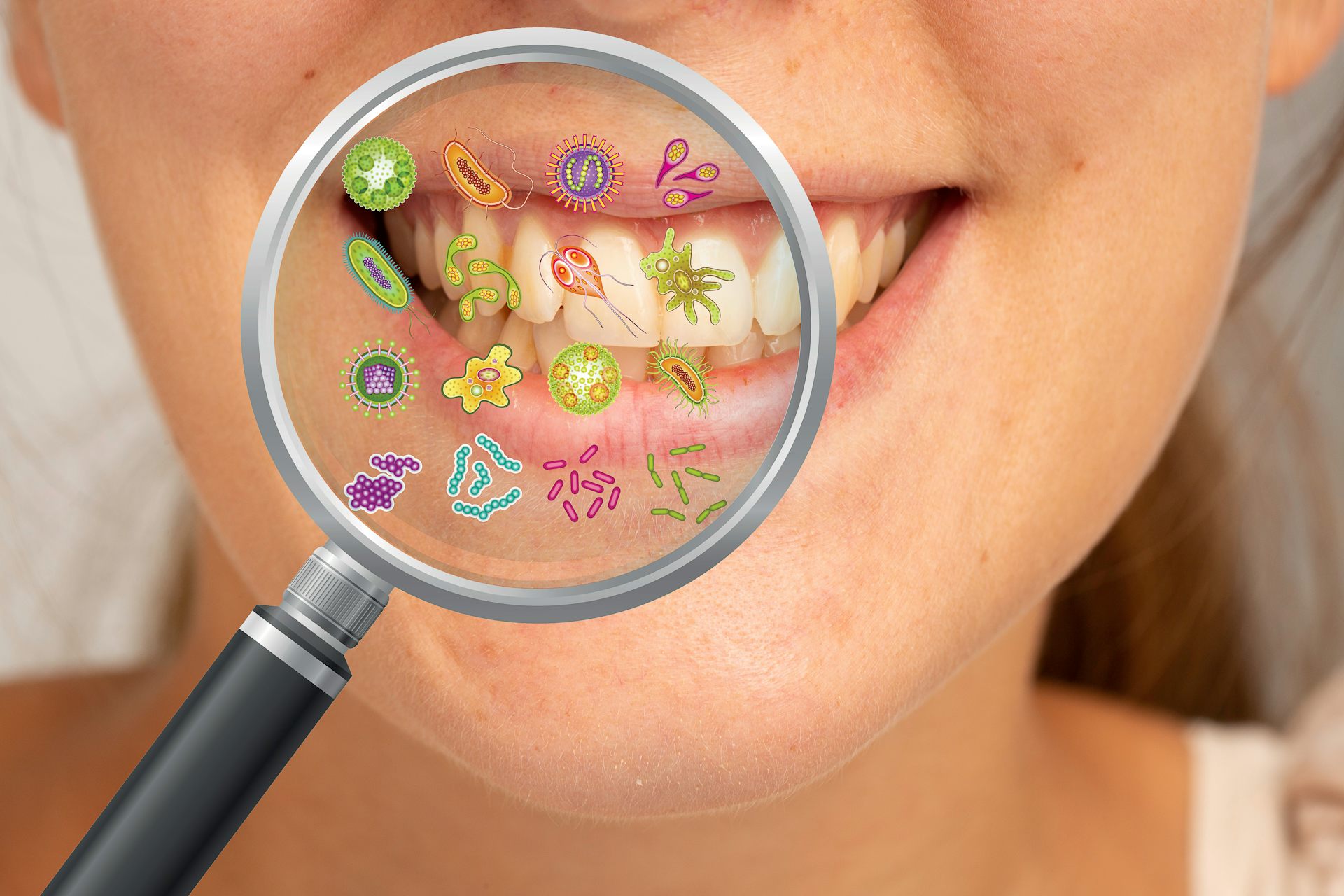 A woman smiles with her teeth. A magnifying glass is held in front of her teeth, depicting the many small microbes and bacteria that may be living inside her mouth..