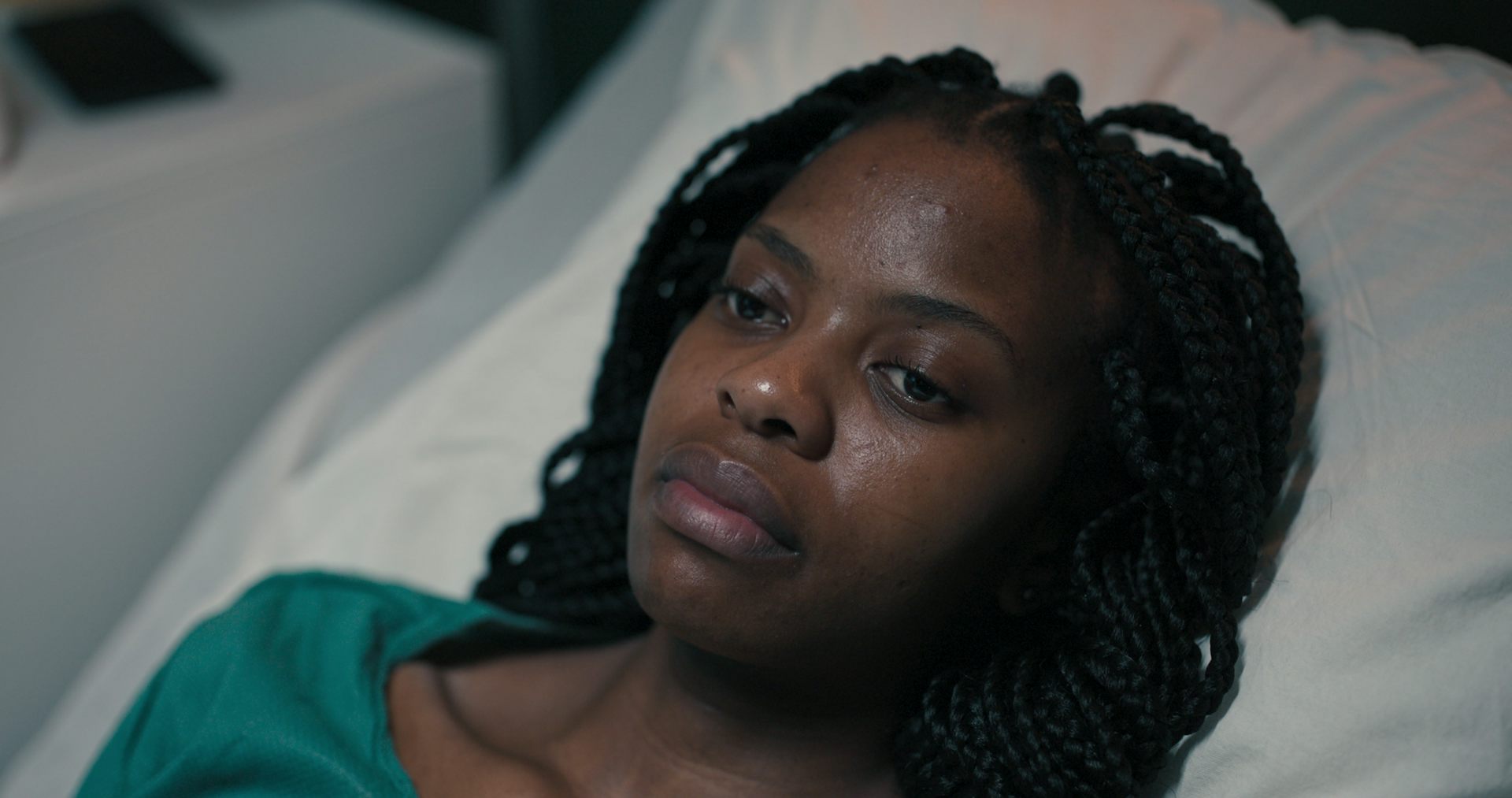 Une femme afro-descendante sur un lit d’hôpital.