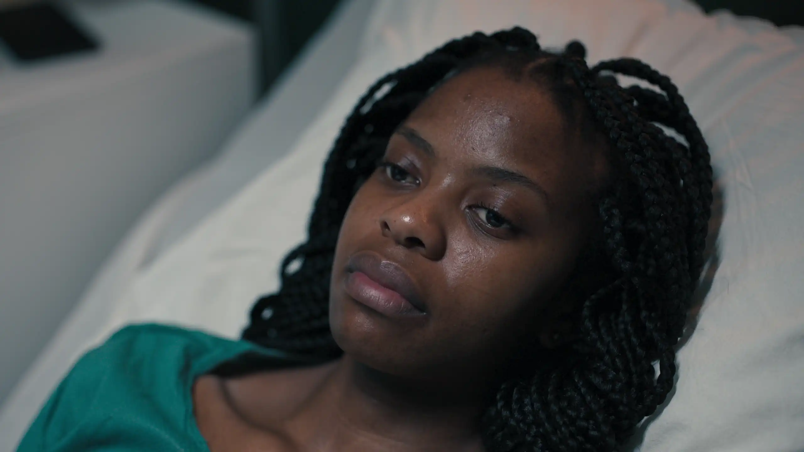 Une femme afro-descendante sur un lit d’hôpital.