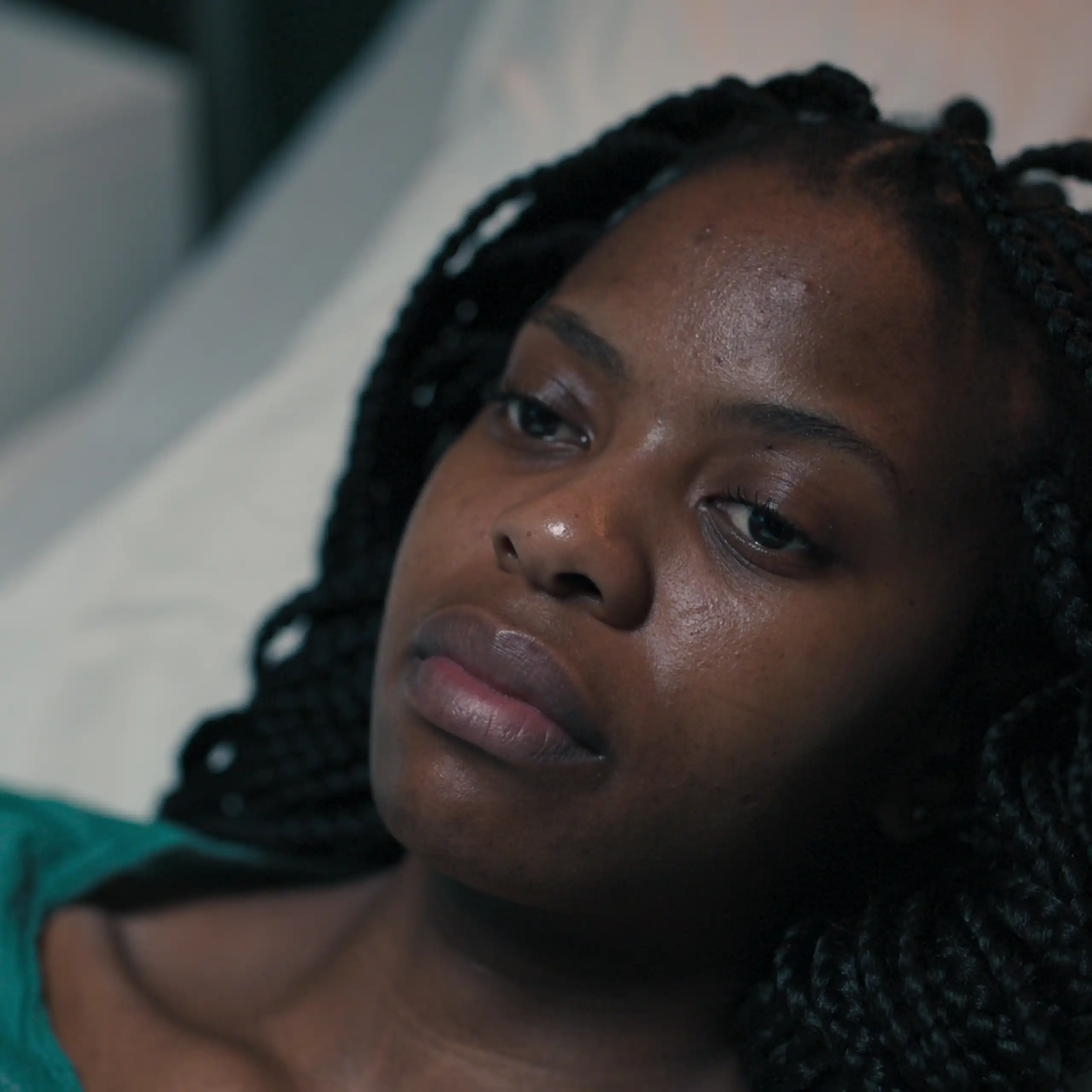 Une femme afro-descendante sur un lit d’hôpital.