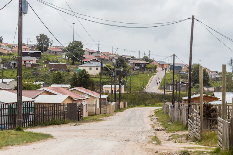 Unpaved road with small houses and electricity lines