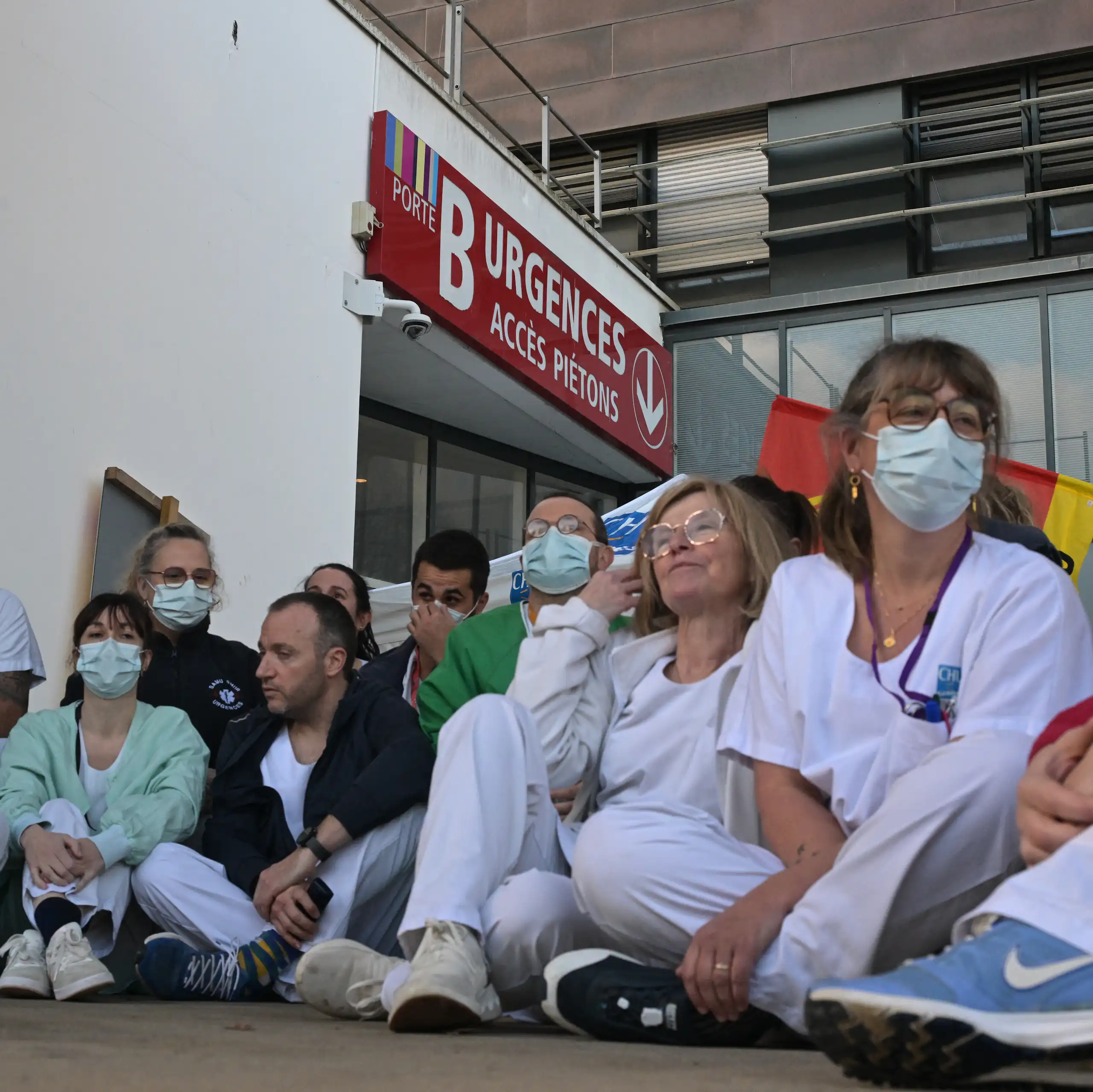 Le personnel soignant des urgences du CHU de Rennes en grève, le 14 janvier 2026. Les soignants sont assis par terre, devant la porte des urgences.