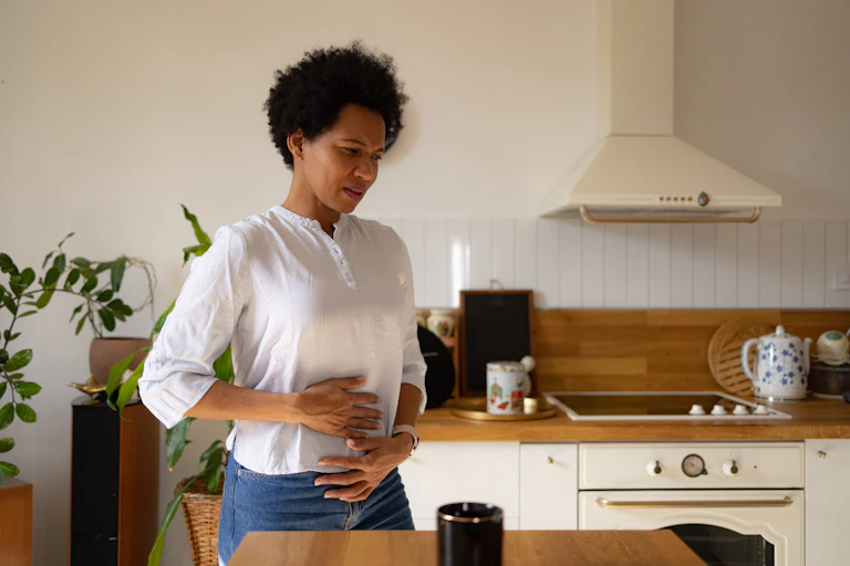 Woman holds her stomach in pain