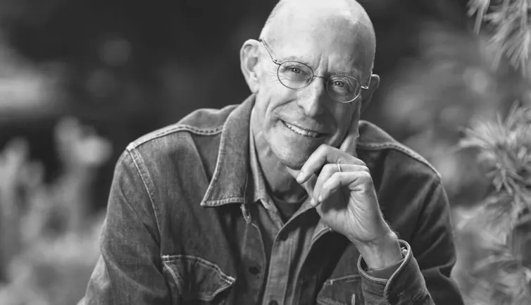 a bald man wearing glasses, smiling