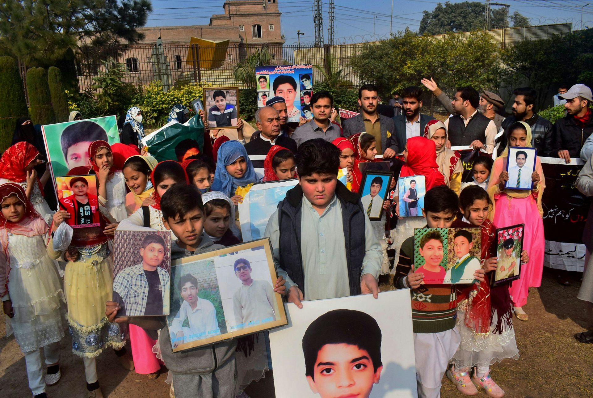 Pakistani families carry photos of relatives killed in a 2014 attack by TTP fighters on Peshawar's army public school.