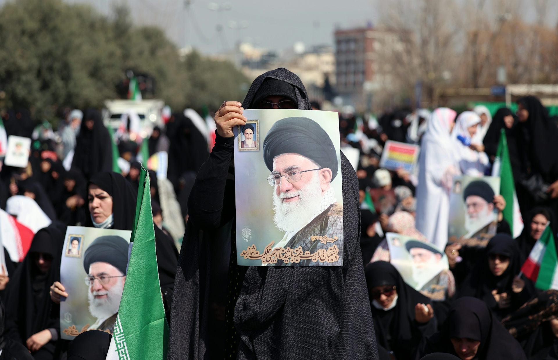Iranian women hold up pictures of the assassinated supreme leader, Ali Khamenei.
