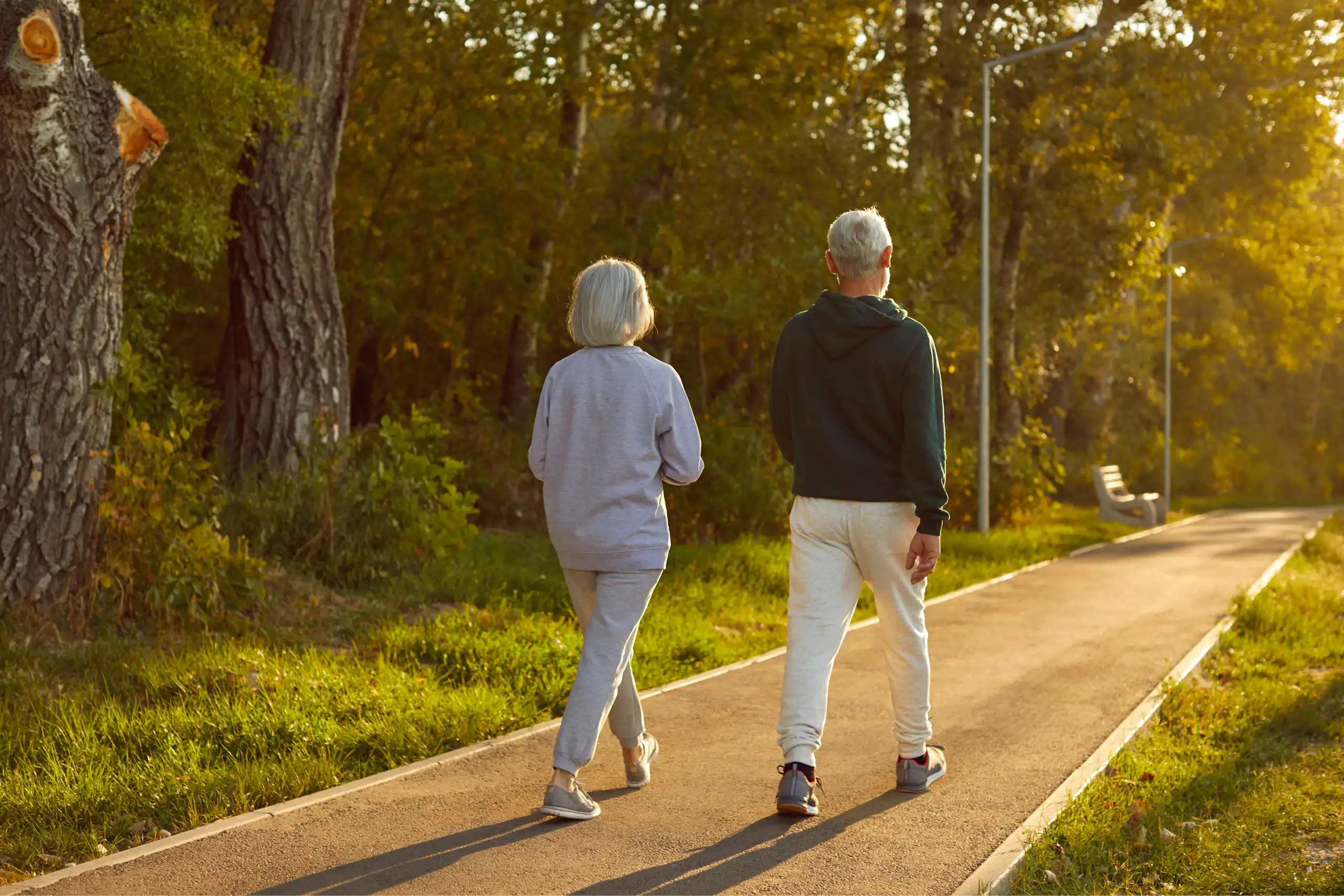 Un home i una dona majors caminen per un bosc.