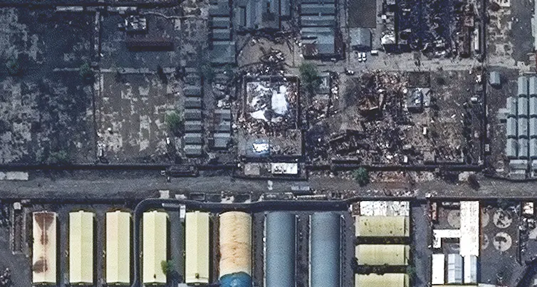 A satellite image shows a smoking plot of land in an urban setting.