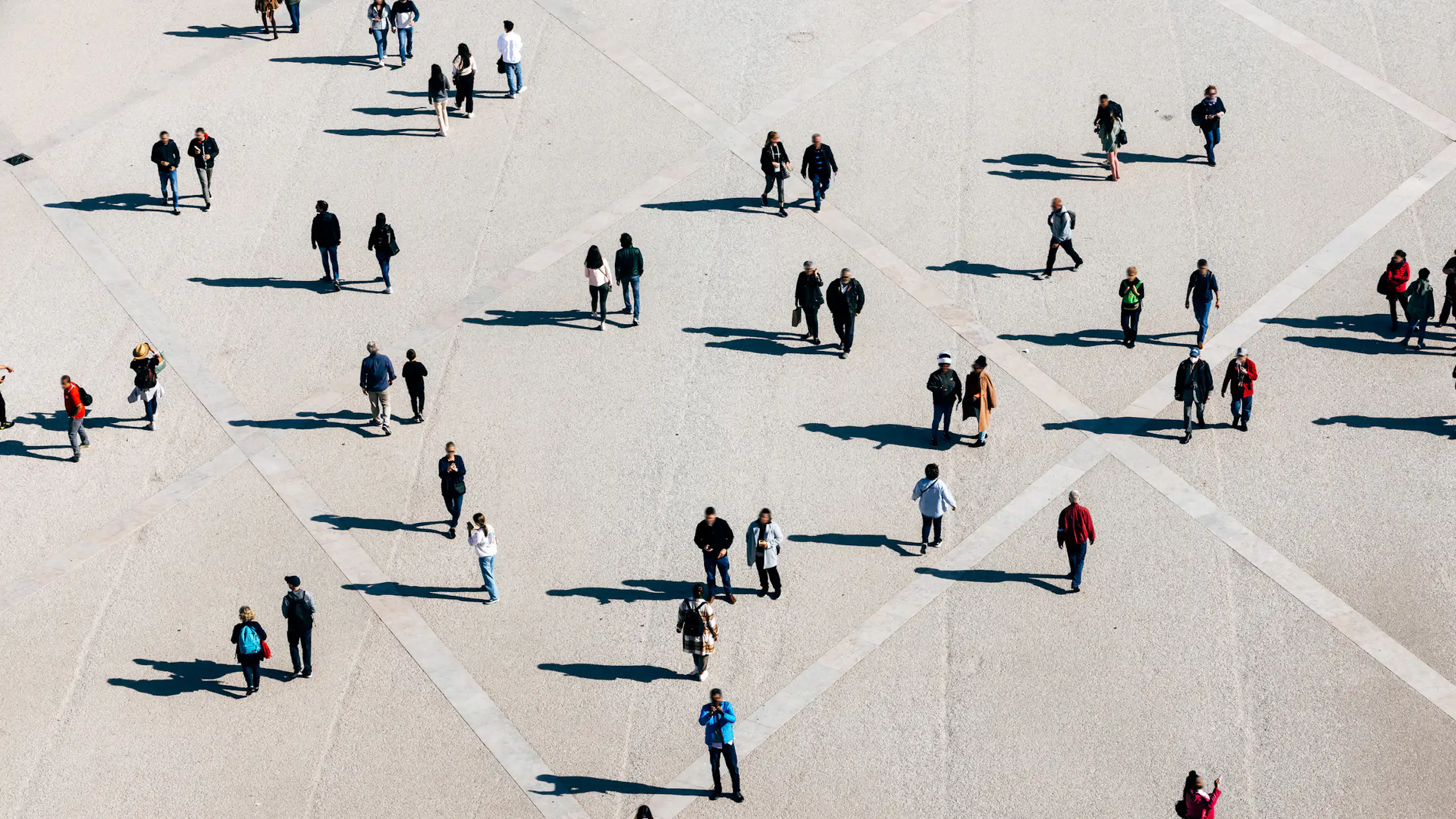 An aerial shot of people and their shadows.