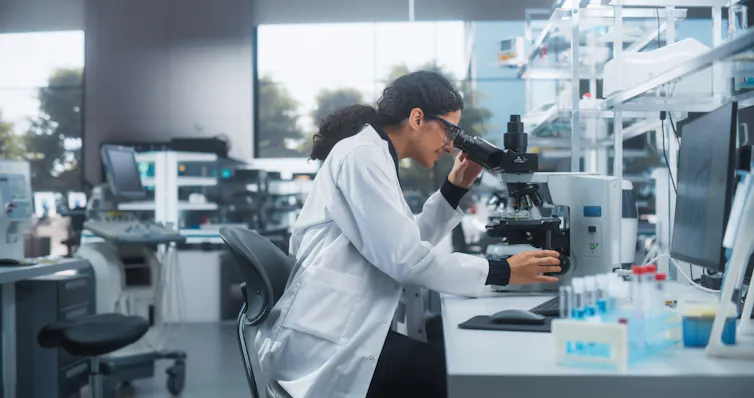 Science student looking through microscope