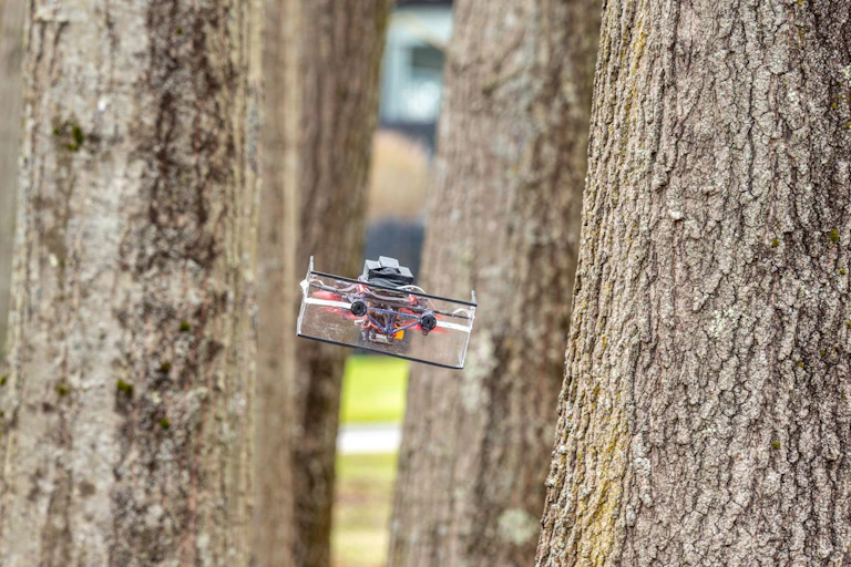 a small boxy drone in a grove of trees