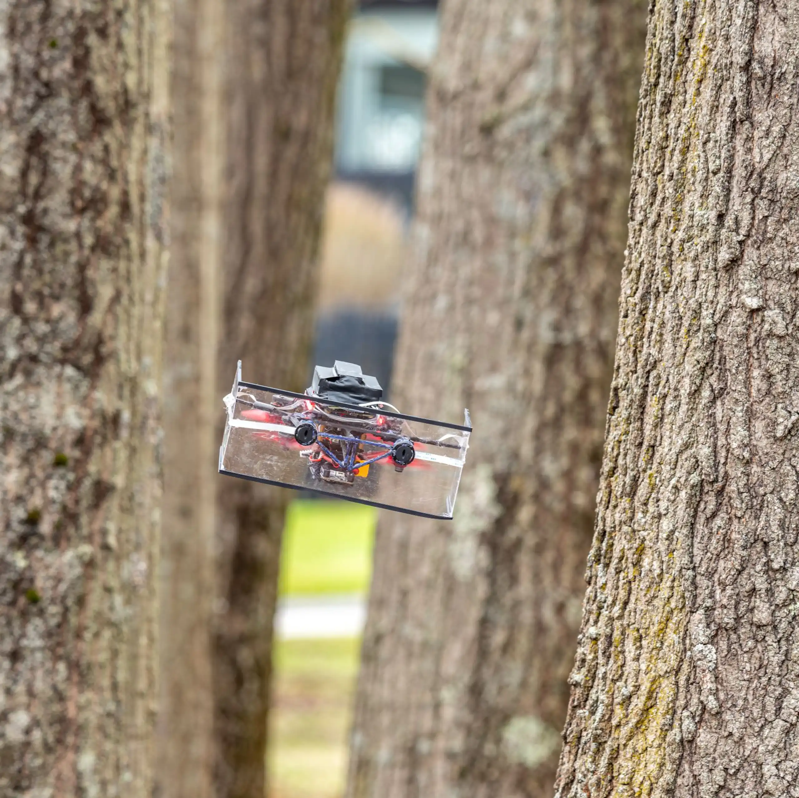 a small boxy drone in a grove of trees