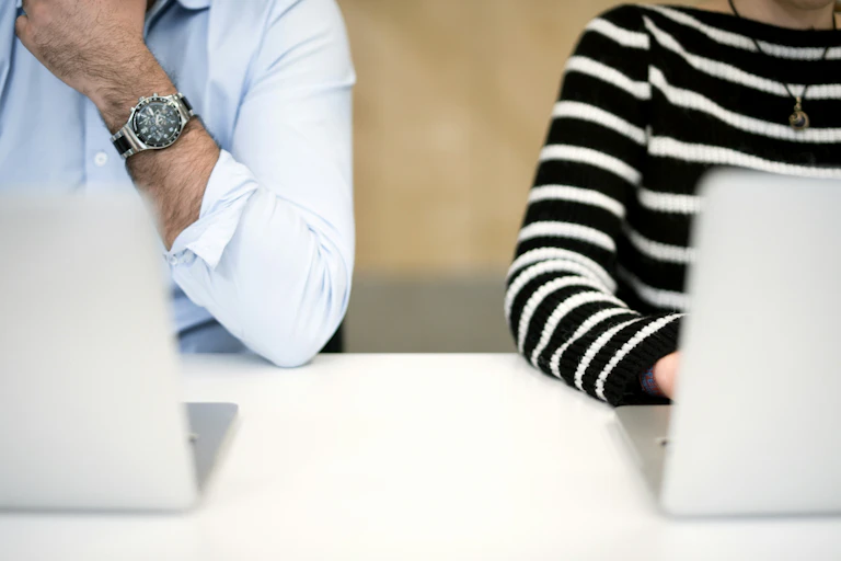 Photo of a man and woman sitting next to each other at computers