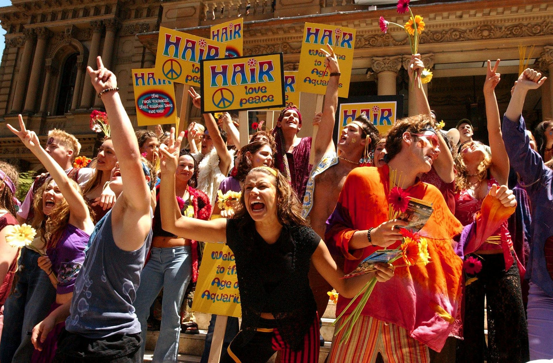 People waving HAIR placards in a crowd.