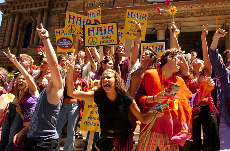 People waving HAIR placards in a crowd.