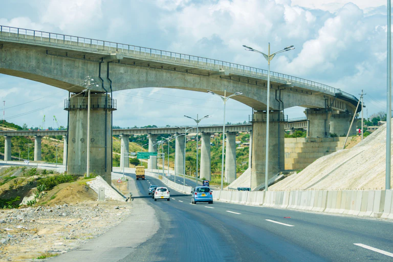 Cars on the road under a railway overpass bridge