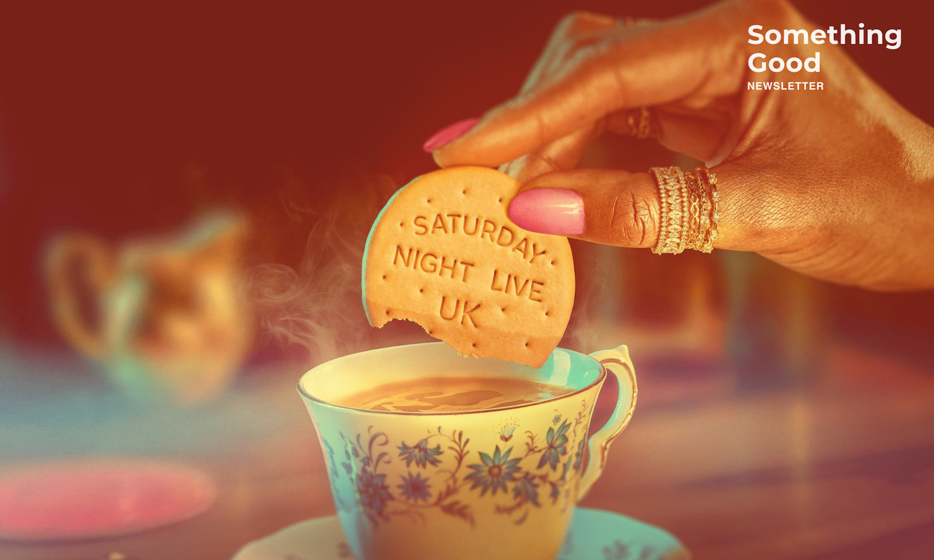 Woman dunking a  biscuit that says Saturday Night Live Uk in a cup of tea. 