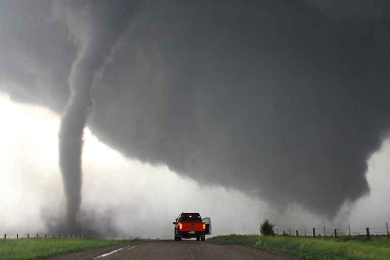 Um caminhão estacionado perto de um tornado.
