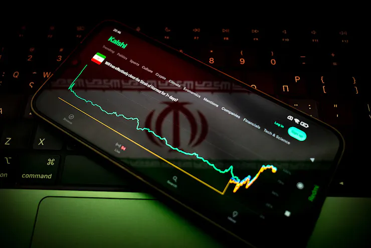 The Kalshi market for 'Will Iran effectively close the Strait of Hormuz for 7+ days?' appears on a smartphone screen.
