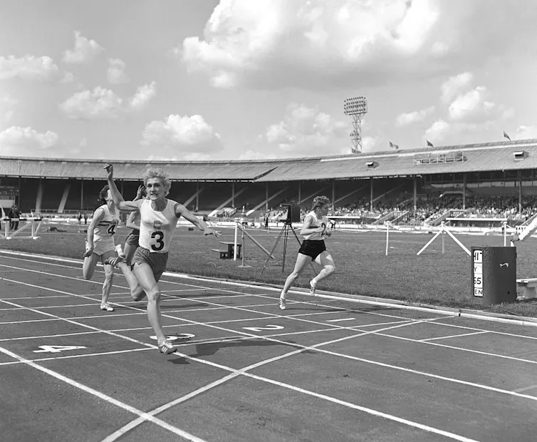 Black-and-white photo of athletes running on a track