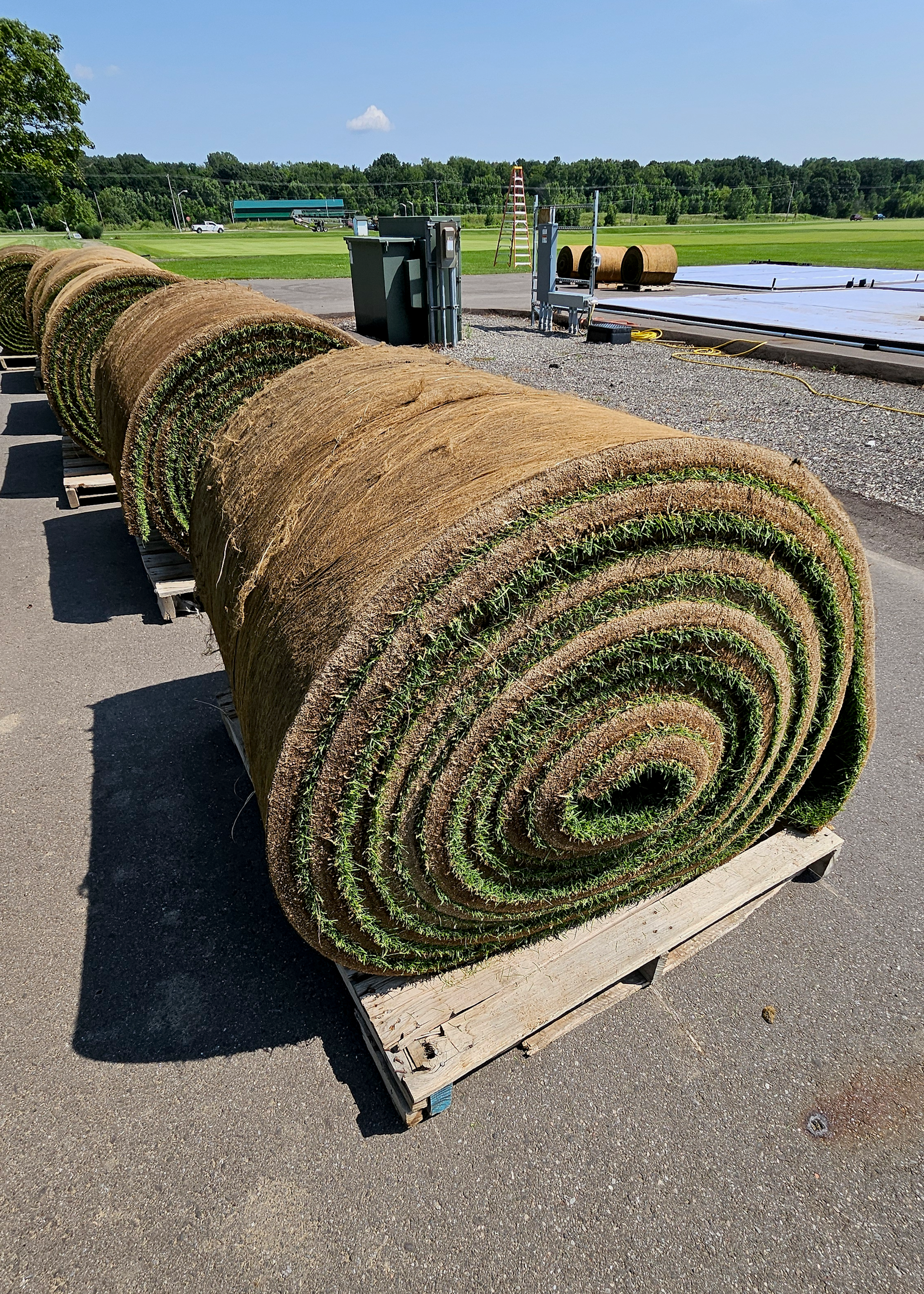 Grandes rollos de césped esperan ser entregados.