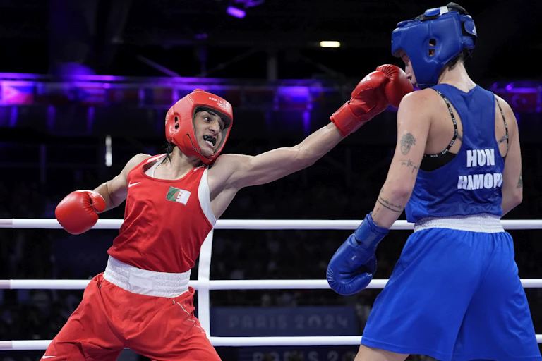 Two boxers in the ring as one swings at the other.