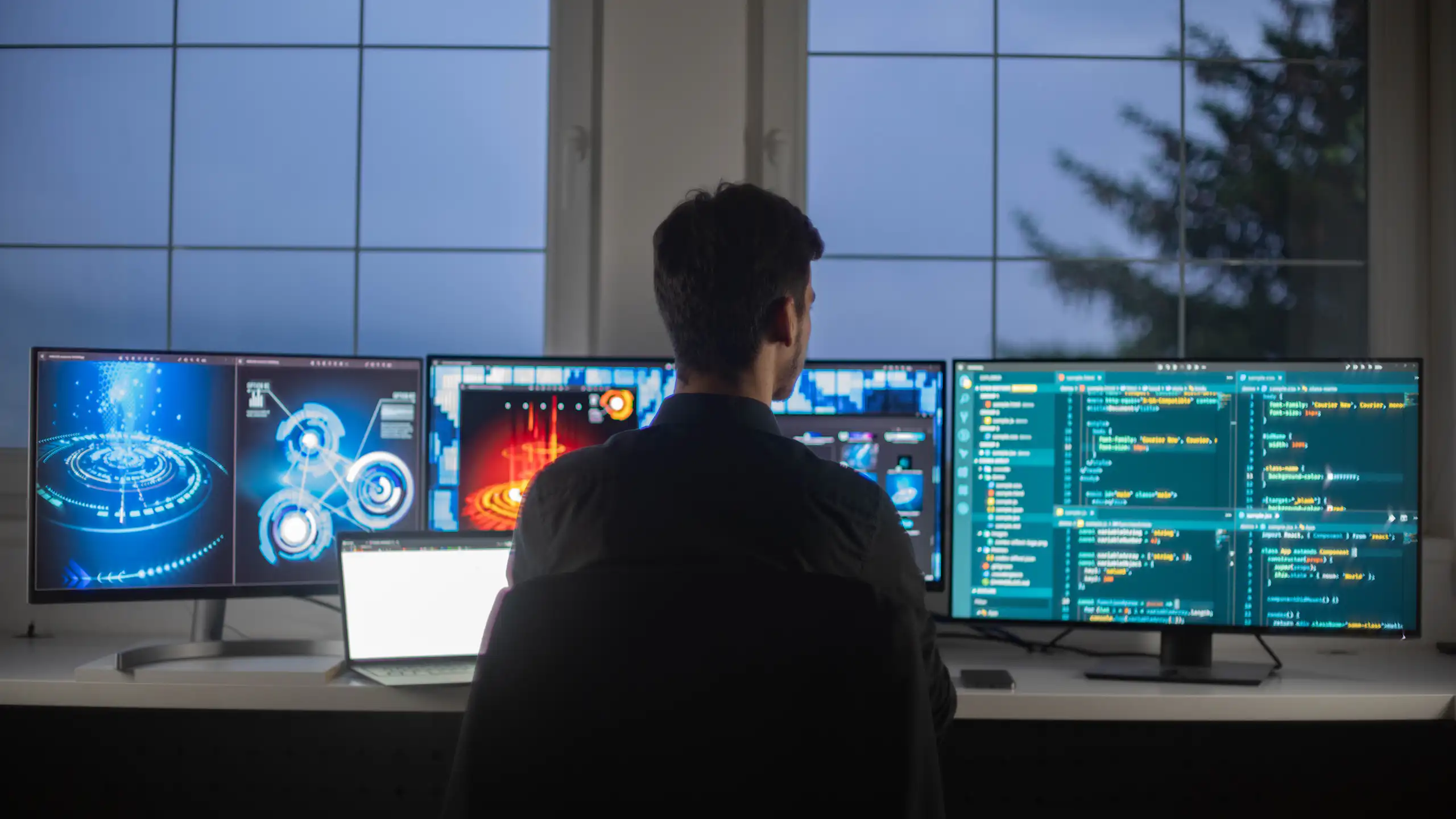 A person in front of several computer screens