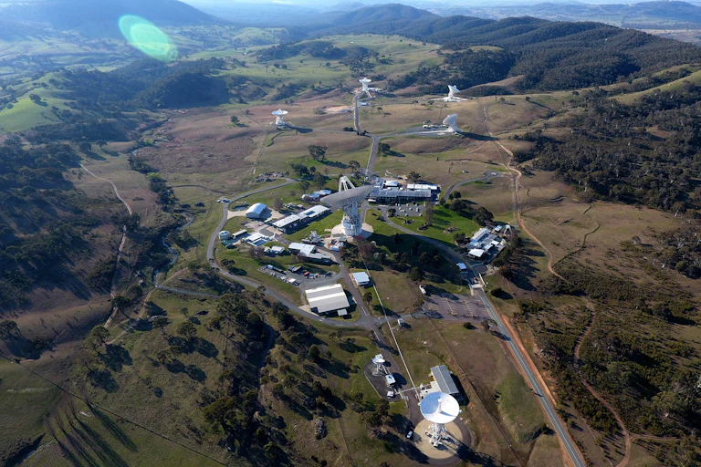 Aerial view of an Australian landscape with space signal dishes and support buildings.